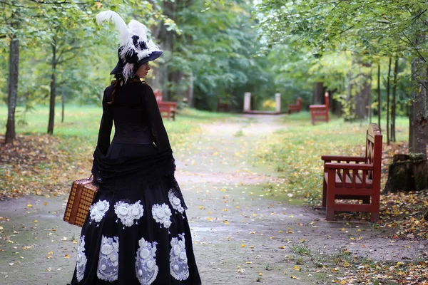 Fille en robe rétro 18ème siècle avec valise dans le parc — Photo