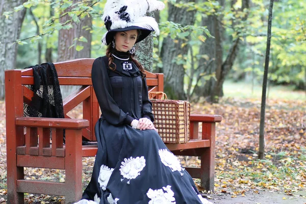 Girl in retro dress past century read letter on the bench — Stock Photo, Image