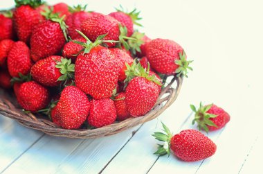 Hasır plaka ahşap arka plan üzerinde çilek