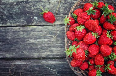 Hasır plaka ahşap arka plan üzerinde çilek