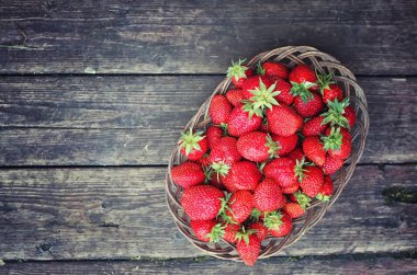 Hasır plaka ahşap arka plan üzerinde çilek