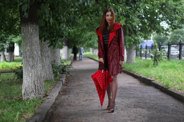 kadın bir yağmurluk ve şemsiye