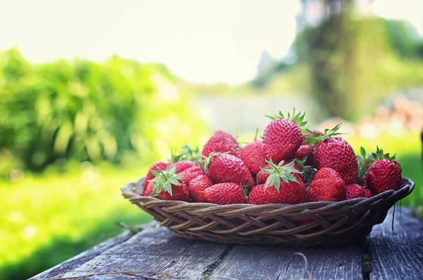 Hasır plaka ahşap arka plan üzerinde çilek