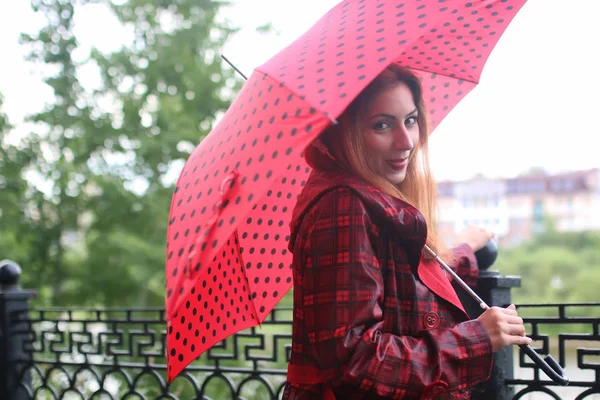 Femme avec parapluie rouge sur arbre de rue — Photo