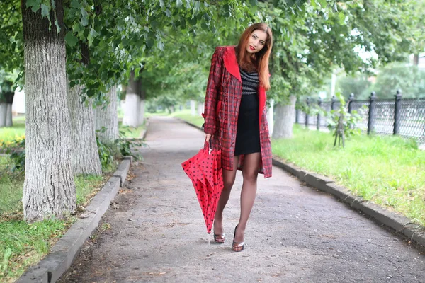 Mulher com guarda-chuva vermelho na árvore de rua — Fotografia de Stock