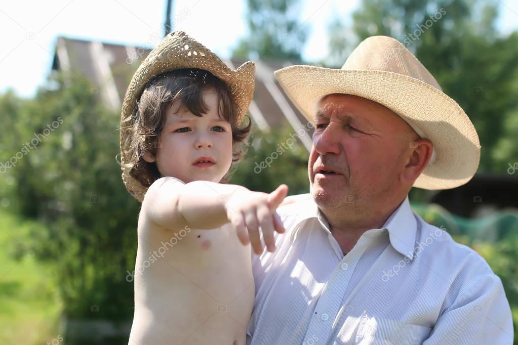 child and grandfather in cowboy hats