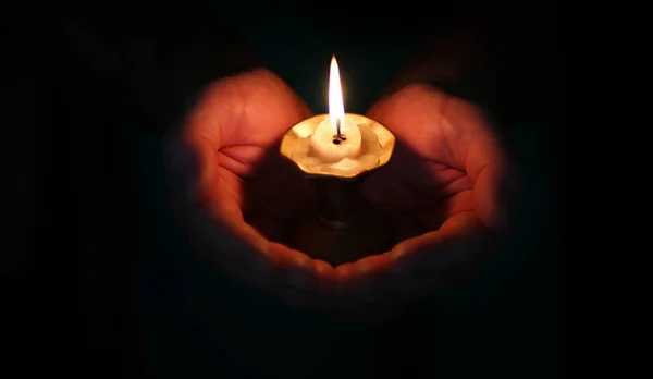 Brinnande ljus i en hand — Stockfoto