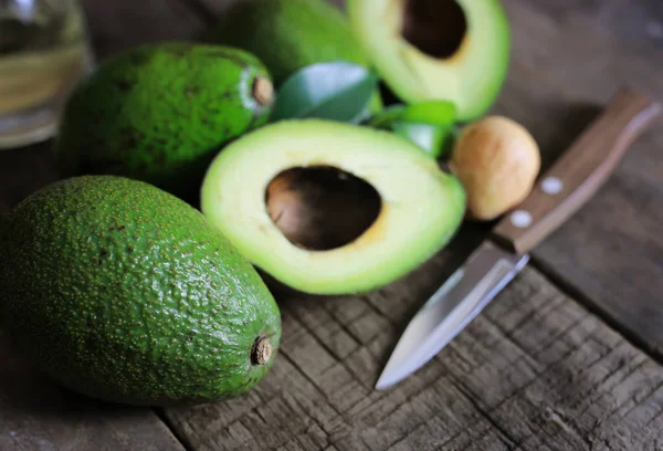 Aguacate y aceite sobre fondo de madera —  Fotos de Stock