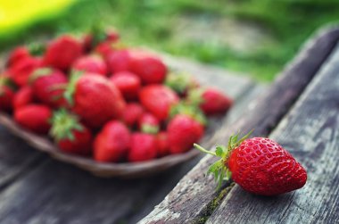 Hasır plaka ahşap arka plan üzerinde çilek