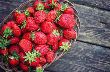 Hasır plaka ahşap arka plan üzerinde çilek