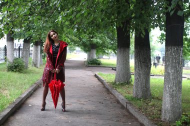 kadın bir yağmurluk ve şemsiye