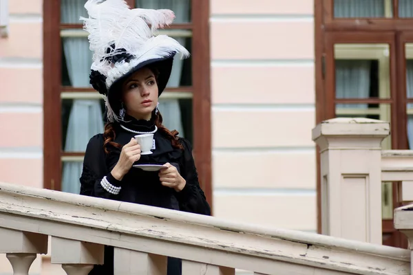 Vrouw in vintage jurk op veranda van kasteel — Stockfoto