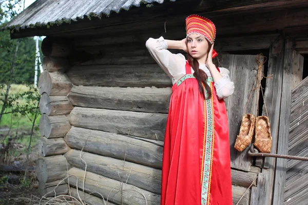 Chica en vestido tradicional pared de madera — Foto de Stock