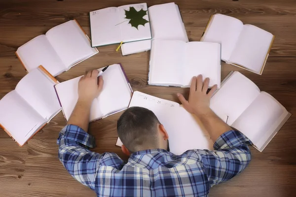 Man arbetar med boken på golvet — Stockfoto