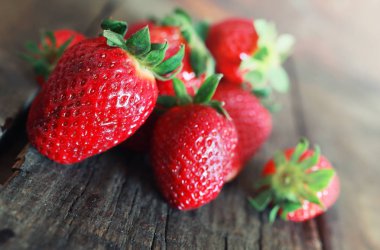 Tahta arka planda taze çilekler.