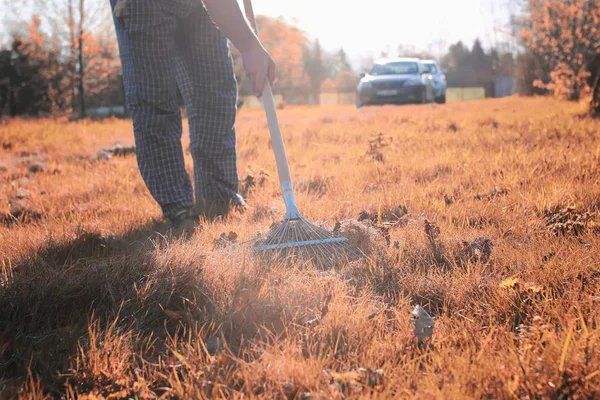 Mann mit Rechen im herbstlichen Gras — Stockfoto