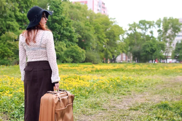 Žena v parku venkovní kufr retro šaty — Stock fotografie
