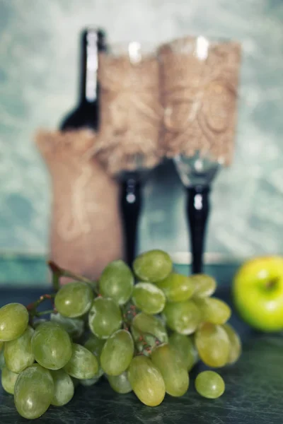 Праздничный набор бутылку вина с зеленым виноградом на заднем плане — стоковое фото