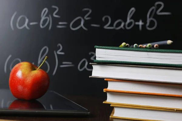 Manzana roja en el cuaderno con pila de libros —  Fotos de Stock