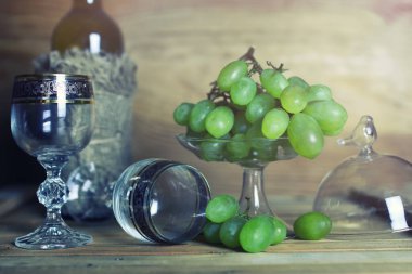 üzüm ve şarap şişesi kitap ile ahşap masa