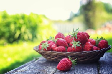 Hasır plaka ahşap arka plan üzerinde çilek
