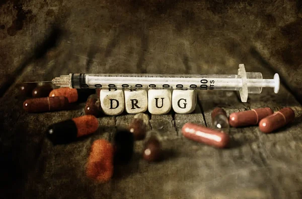 Narkoman staré omšelé špinavé Foto drog pilulku na dřevěný stůl concept — Stock fotografie