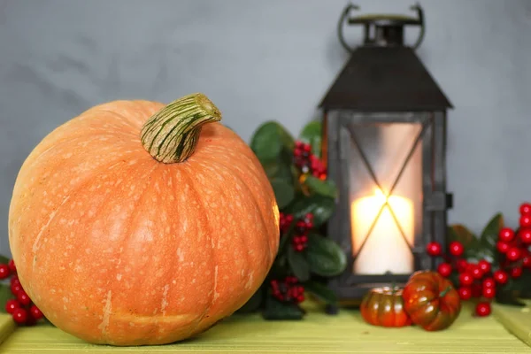 Citrouille et lampe sur table en bois — Photo