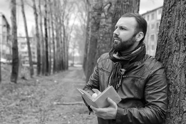 Kışın açık havada kitap okuyan bir adam.