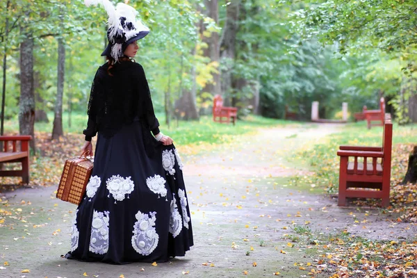 Fille en robe rétro 18ème siècle avec valise dans le parc — Photo