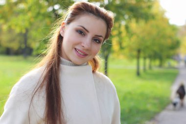 Sonbaharda parkta yürüyen kız.
