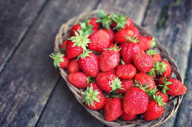 Hasır plaka ahşap arka plan üzerinde çilek