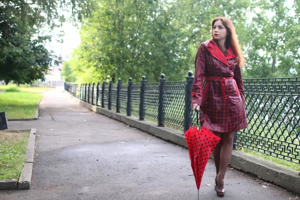 Mulher com guarda-chuva vermelho na árvore de rua — Fotografia de Stock