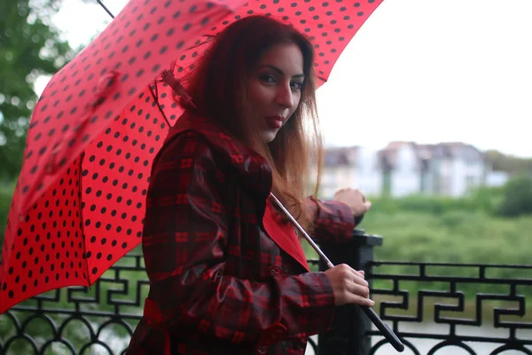 Donna con un impermeabile e un ombrello — Foto Stock