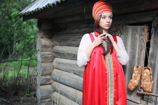 Chica en vestido tradicional pared de madera —  Fotos de Stock