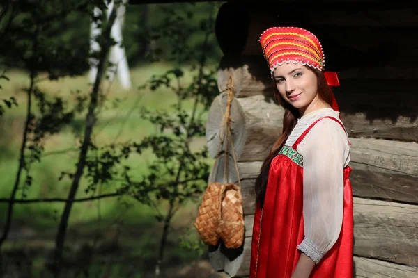 Ragazza in abito tradizionale parete di legno — Foto Stock