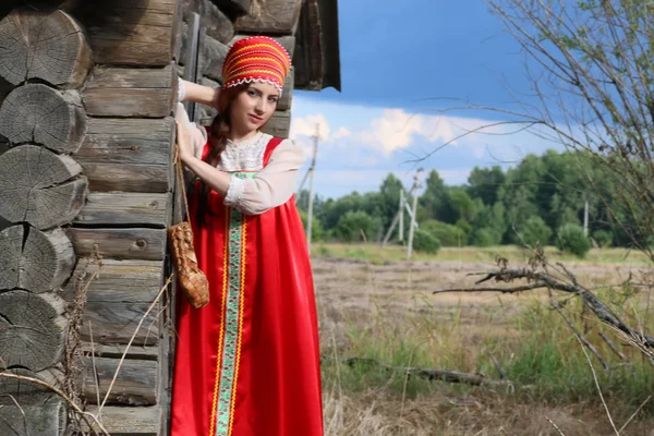 Dívka v tradičním kroji dřevěné zdi — Stock fotografie