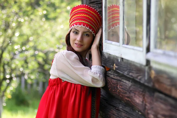 Mujer eslava en la pared de madera vestido tradicional — Foto de Stock