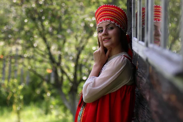 Escravo mulher no vestido tradicional parede de madeira — Fotografia de Stock