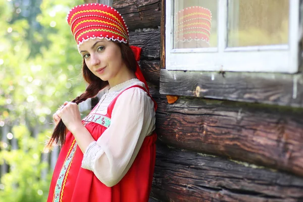 Mujer eslava en la pared de madera vestido tradicional — Foto de Stock