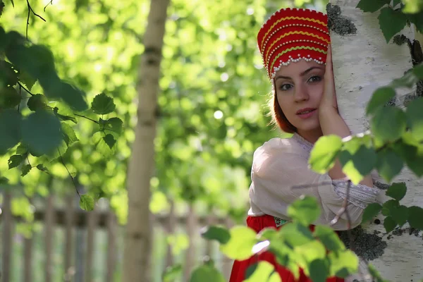 Slav in traditional dress hiding behind trees — Stock Photo, Image