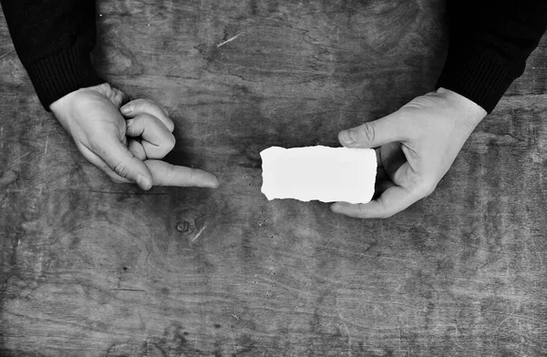 紙の白い空白のシートを保持しているモノクロ写真男性の手 — ストック写真