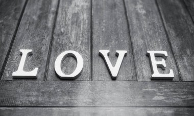 ahşap arka plan üzerinde beyaz tahta harflerle yapılan kelime aşk
