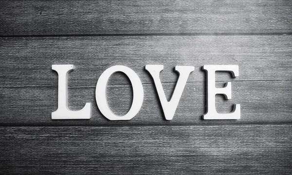 Слово любов з білих дерев'яних літер на дерев'яному фоні — стокове фото