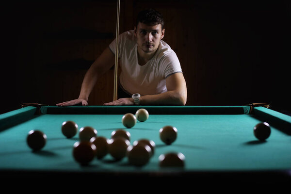 hansome man playing billiards alone