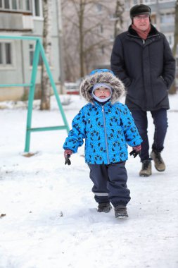 Çocuklar kışın bahçede karla oynuyorlar.