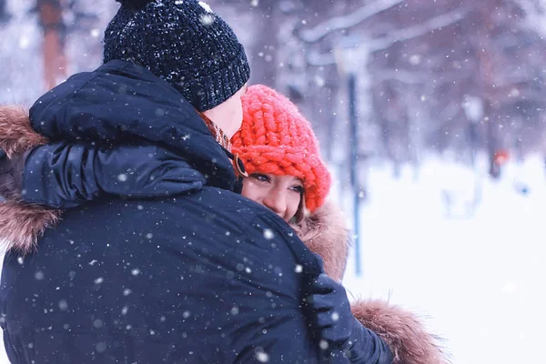 Мужчина несет девушку молодой паре зимой — стоковое фото