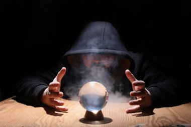 adam siyah başlıklı cristal topu ile