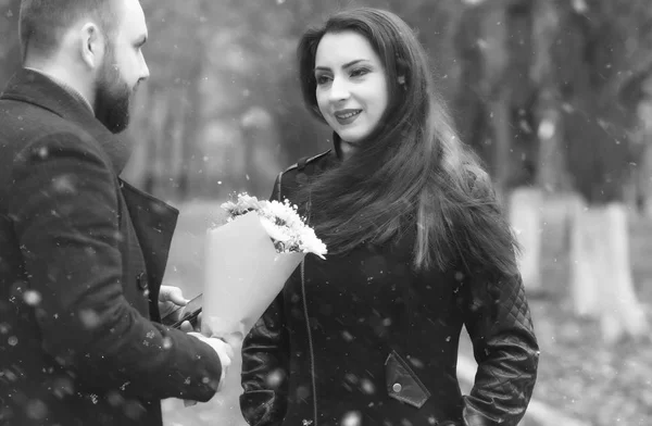 Foto monocromática de data em um parque amantes em um banco na neve — Fotografia de Stock