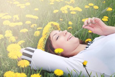 Sarı dandelions çayırda güneşli bir dinlenme kız