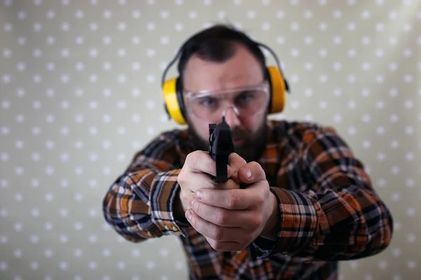 Hombre con gafas protectoras y entrenamiento de orejas en pistola sh —  Fotos de Stock